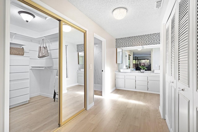 bathroom featuring hardwood / wood-style floors, vanity, and a textured ceiling