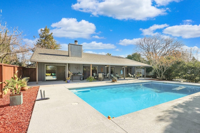 view of pool with a diving board and a patio area