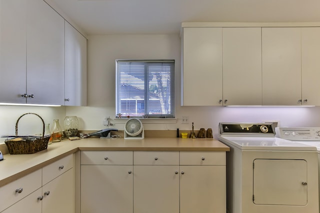 washroom featuring cabinets and independent washer and dryer