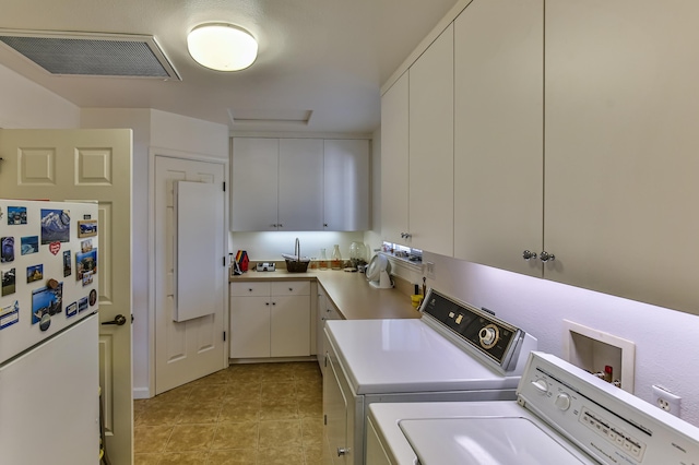 laundry room with separate washer and dryer and cabinets