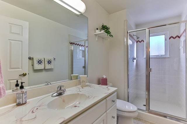 bathroom with vanity, an enclosed shower, and toilet