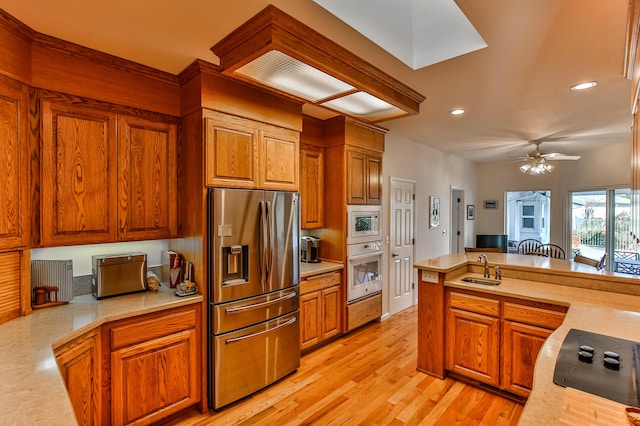 kitchen with sink, wall oven, stainless steel fridge, stovetop, and white microwave