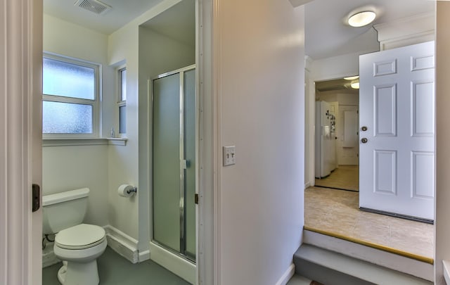 bathroom featuring toilet and an enclosed shower