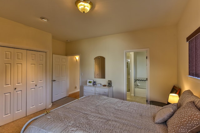 bedroom with light colored carpet, ensuite bath, and a closet