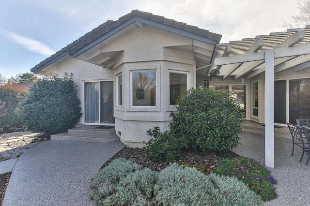 view of exterior entry featuring a pergola