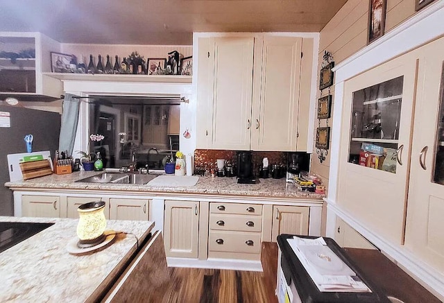 kitchen with light stone counters, sink, white cabinets, and dark wood-type flooring