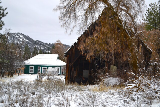 snow covered rear of property with a mountain view