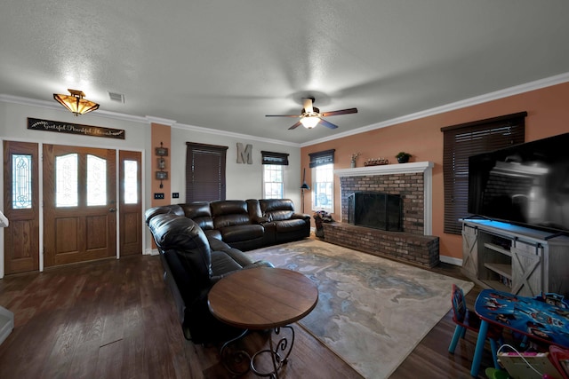 living room with dark hardwood / wood-style flooring, a textured ceiling, ceiling fan, crown molding, and a fireplace