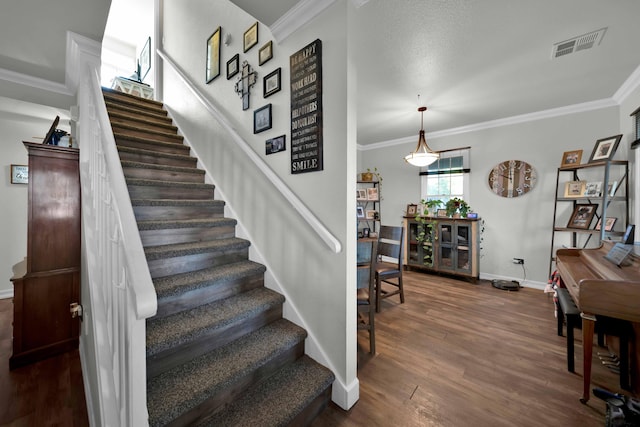 stairway featuring crown molding and wood-type flooring