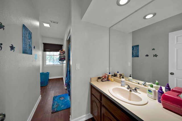 bathroom featuring hardwood / wood-style floors, vanity, and a textured ceiling