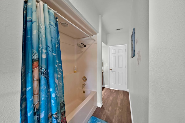 bathroom with hardwood / wood-style floors and shower / bathtub combination with curtain