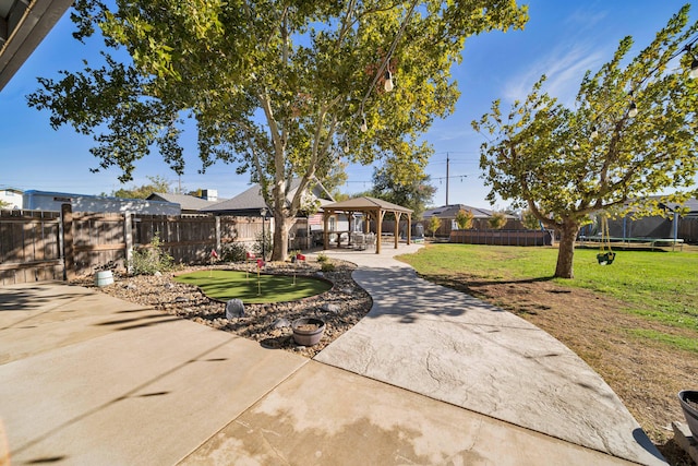 ranch-style home with a gazebo, a trampoline, a front lawn, and a patio area