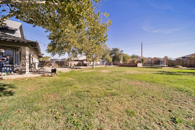 view of yard featuring a trampoline and a patio area