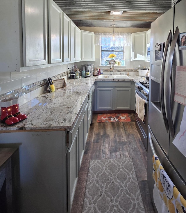 kitchen featuring pendant lighting, sink, dark hardwood / wood-style flooring, wood ceiling, and stainless steel appliances