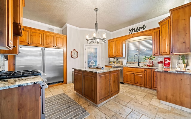 kitchen with stainless steel appliances, sink, a chandelier, a center island, and hanging light fixtures