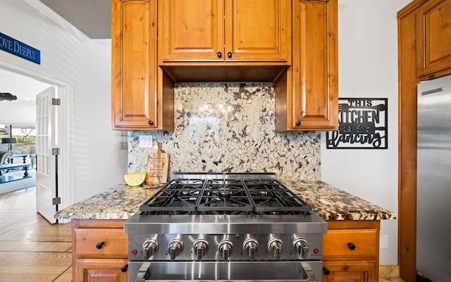 kitchen with tasteful backsplash, light stone countertops, and appliances with stainless steel finishes