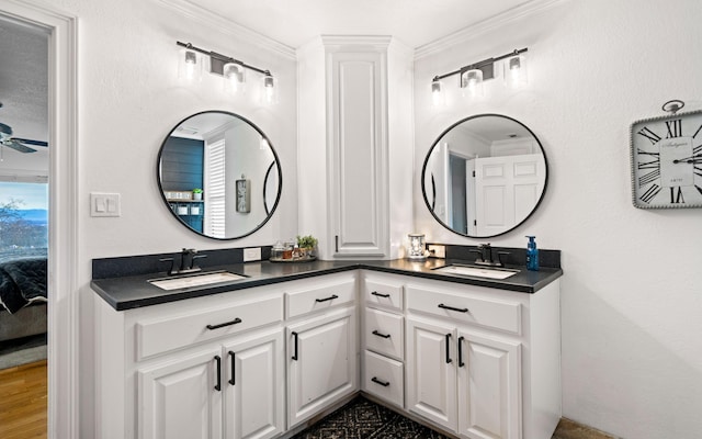 bathroom featuring vanity, crown molding, and ceiling fan