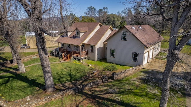 7899 Elmers Way, Shingletown, CA 96088 - rear view of house featuring concrete driveway, a lawn, a wooden deck, and a shingled roof