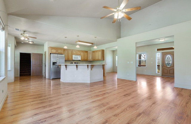 7899 Elmers Way, Shingletown, CA 96088 - kitchen with stainless steel refrigerator with ice dispenser, white microwave, ceiling fan, a breakfast bar, and open floor plan
