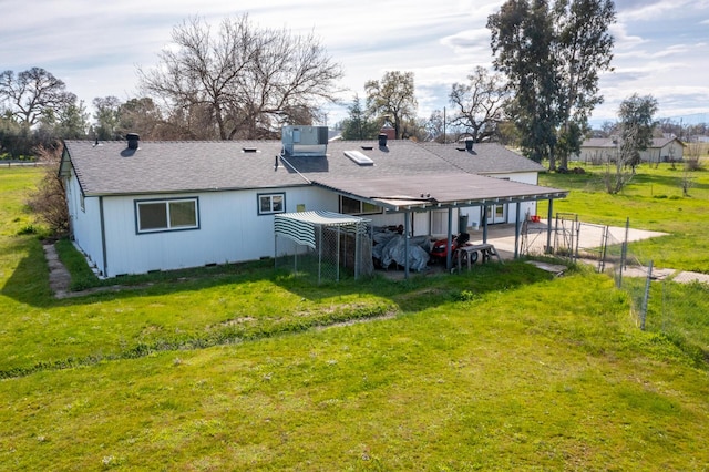 rear view of house with a detached carport, fence, driveway, a patio area, and a lawn