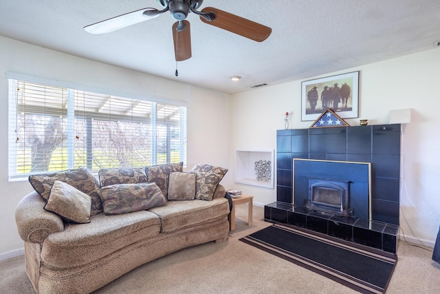 living area with visible vents, baseboards, carpet, and a textured ceiling