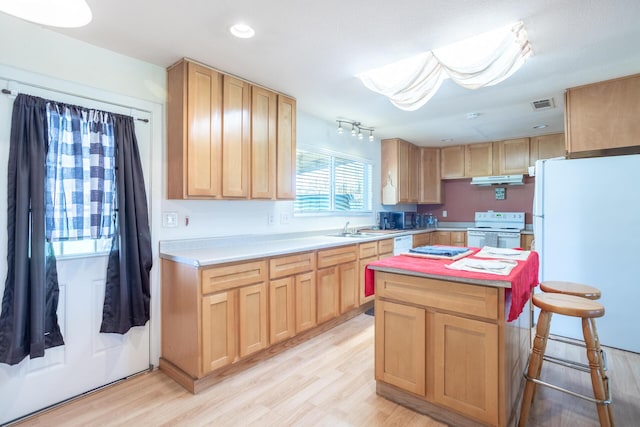 kitchen featuring visible vents, light brown cabinets, light countertops, light wood-style flooring, and white appliances