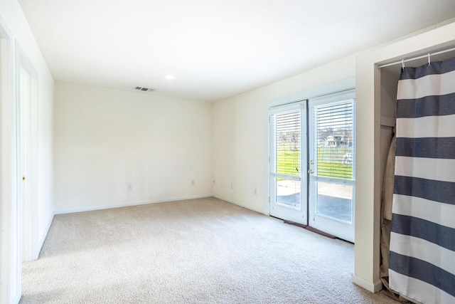 empty room featuring baseboards, visible vents, and carpet floors