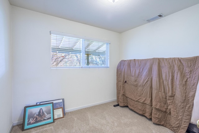 carpeted bedroom featuring baseboards and visible vents