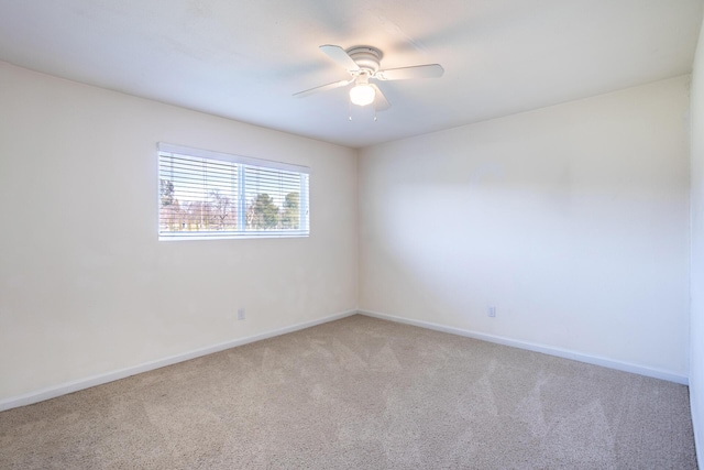 empty room with a ceiling fan, light colored carpet, and baseboards