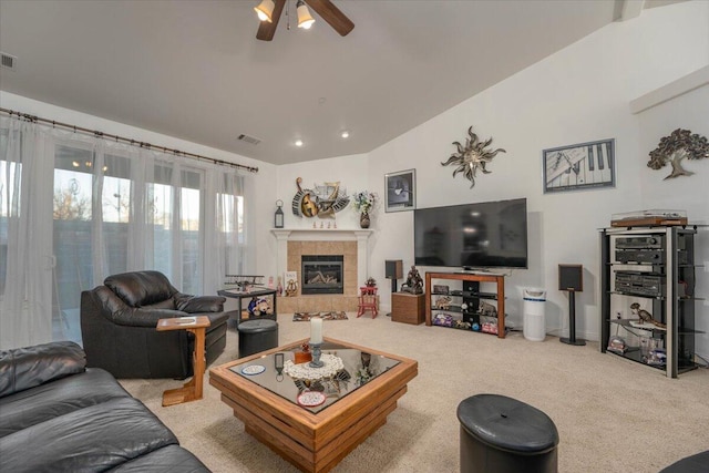 living room featuring a tiled fireplace, light carpet, ceiling fan, and lofted ceiling