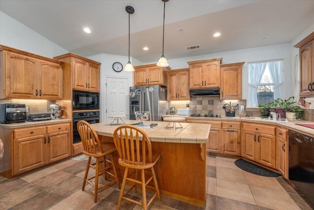 kitchen featuring a center island, tasteful backsplash, vaulted ceiling, a kitchen bar, and black appliances