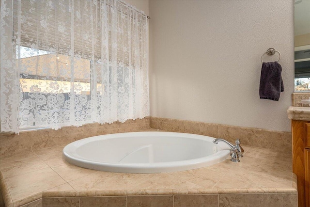 bathroom featuring vanity and tiled bath