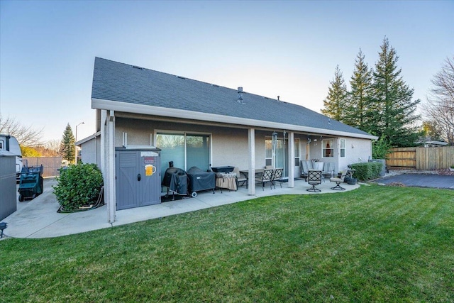 rear view of property featuring a patio area and a lawn