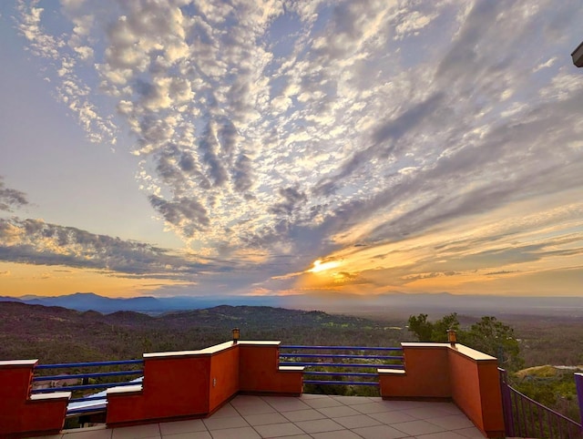 patio terrace at dusk featuring a mountain view