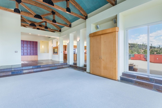 interior space with beamed ceiling and high vaulted ceiling