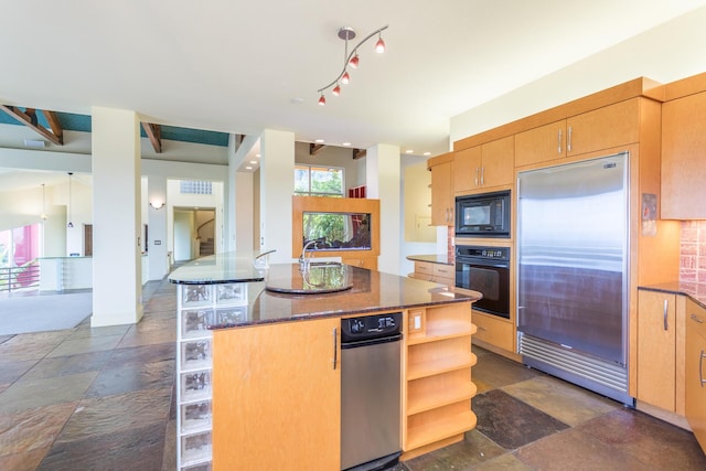 kitchen featuring dark stone counters, sink, black appliances, beamed ceiling, and a kitchen island