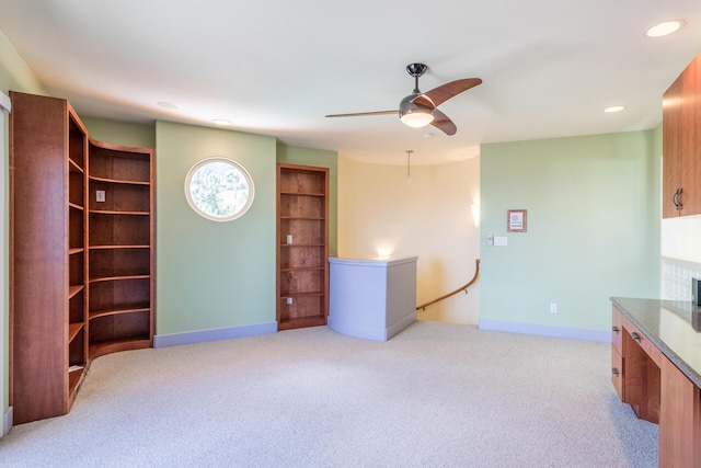 interior space featuring ceiling fan and light colored carpet