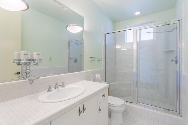 bathroom with tile patterned flooring, vanity, toilet, and walk in shower