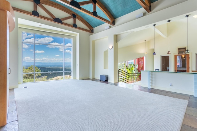 carpeted spare room featuring beam ceiling and high vaulted ceiling