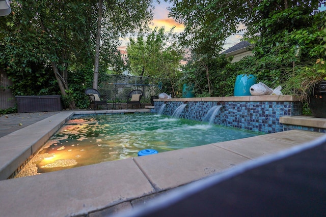 view of pool at dusk