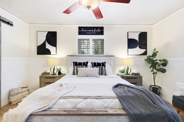 bedroom featuring hardwood / wood-style floors, ceiling fan, and ornamental molding