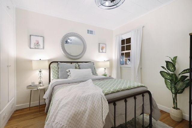 bedroom with wood-type flooring and crown molding