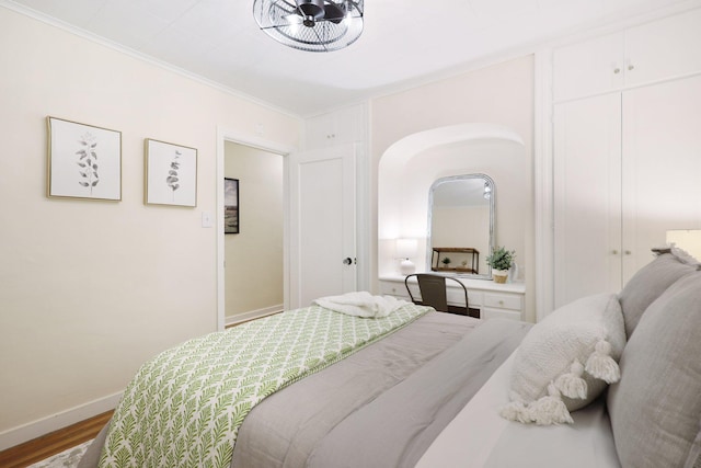 bedroom featuring hardwood / wood-style floors and crown molding