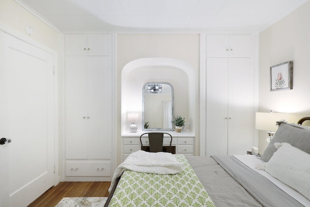 bedroom with wood-type flooring and ornamental molding