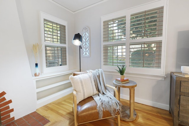 living area featuring hardwood / wood-style flooring, plenty of natural light, and crown molding