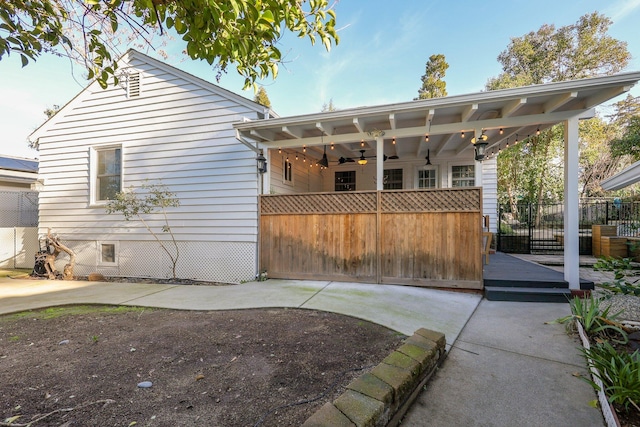 back of property with ceiling fan and a wooden deck