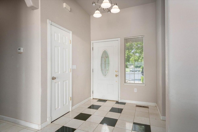 entrance foyer with light tile patterned floors and a notable chandelier