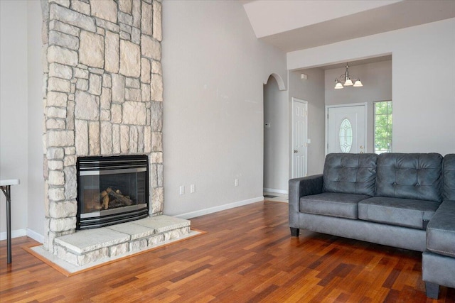 living room featuring a stone fireplace, dark hardwood / wood-style flooring, and high vaulted ceiling