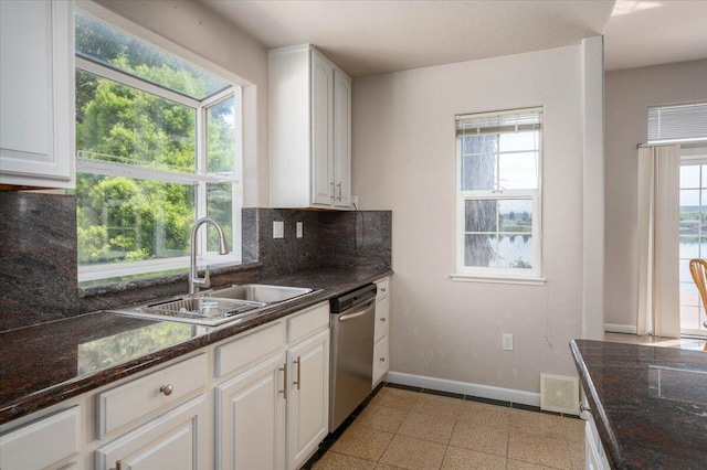 kitchen with white cabinets, tasteful backsplash, sink, dishwasher, and plenty of natural light