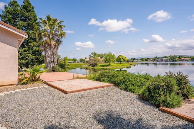 view of yard featuring a water view and a patio